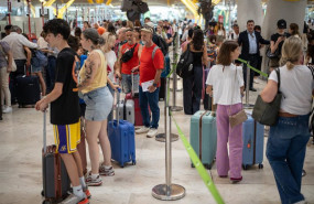 ep archivo   pasajeros con maletas esperan la cola para facturar en el aeropuerto adolfo suarez