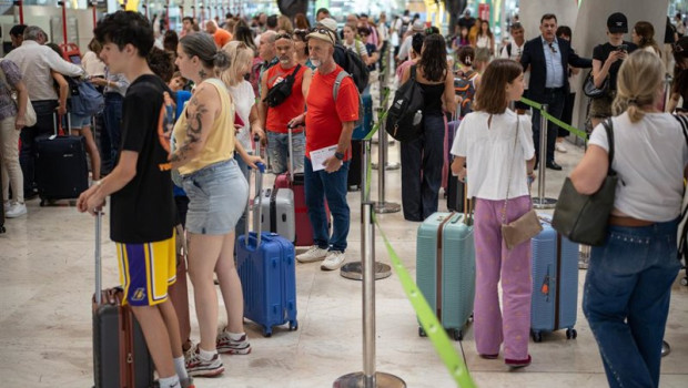 ep archivo   pasajeros con maletas esperan la cola para facturar en el aeropuerto adolfo suarez