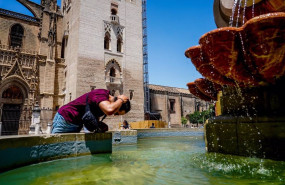 ep un turista se refresca en una fuente de la plaza virgen de los reyes en sevilla andalucia