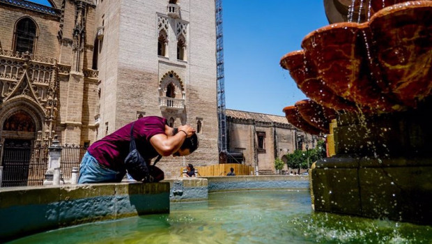 ep un turista se refresca en una fuente de la plaza virgen de los reyes en sevilla andalucia