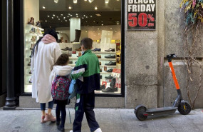 ep varias personas en el escaparate de un comercio que anuncia descuentos del 50 por el black friday