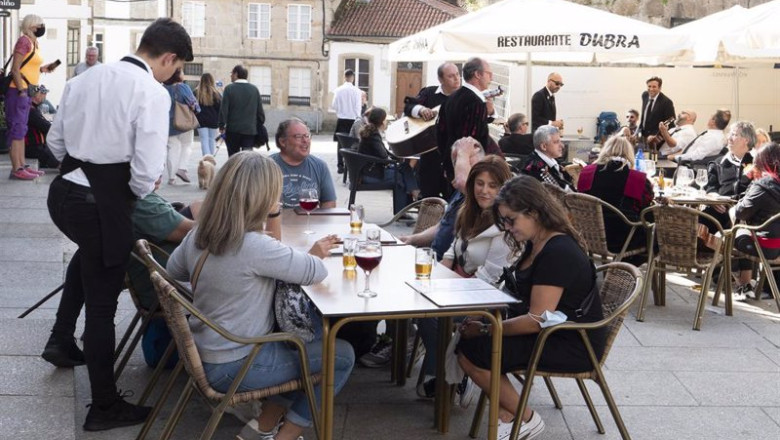 Archivo - Un grupo de turistas consulta una carta en la terraza de un bar en Galicia | César Arxina - Europa Press - Archivo ep archivo un grupo de turistas consulta una carta en la terraza de un bar en galicia