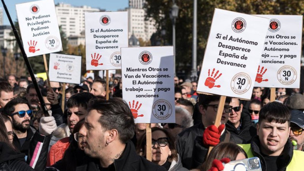 ep manifestantes portan pancartas con lemas mientras otros se van de vacaciones el autonomo trabaja