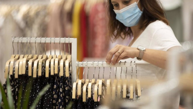ep archivo - mujer con mascarilla en una tienda de ropa