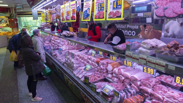 ep varias personas compran en una carniceria en un mercado