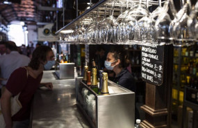 ep archivo   una persona conversa con una camarera durante la reapertura del mercado de san miguel a