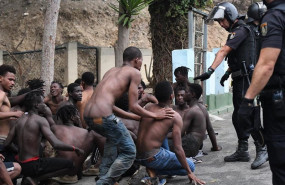 ep imagen de inmigrantes y efectivos policiales ante el salto masivo a la valla de ceuta el 30 de