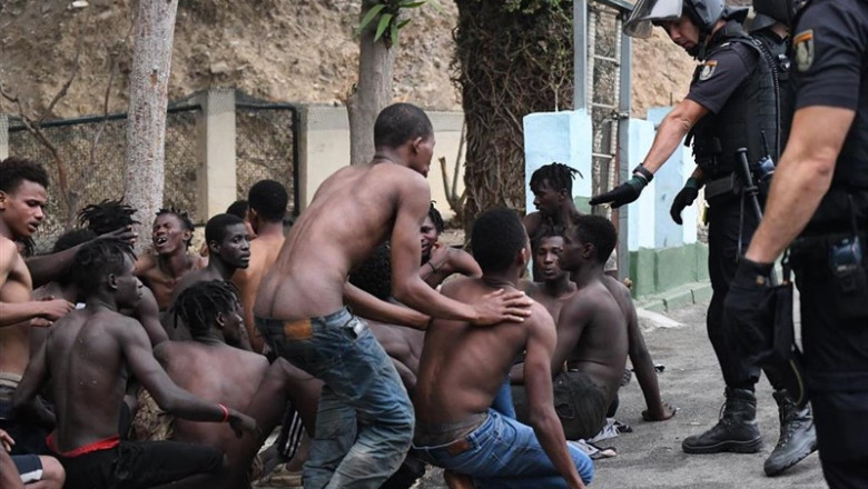 ep imagen de inmigrantes y efectivos policiales ante el salto masivo a la valla de ceuta el 30 de