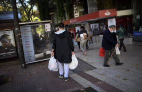 ep un hombre lleva varias bolsas de supermercado