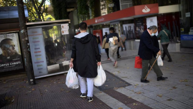 ep un hombre lleva varias bolsas de supermercado