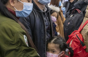 ep a young girl is calmed by her parents as they wear protecive masks on board an airport transit