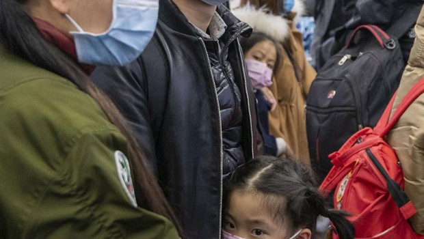 ep a young girl is calmed by her parents as they wear protecive masks on board an airport transit