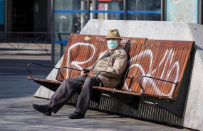 ep un hombre con mascarilla sentado en un banco en madrid durante la crisis del coronavirus en