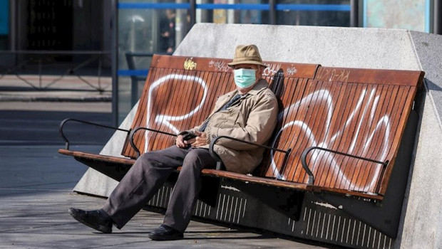 ep un hombre con mascarilla sentado en un banco en madrid durante la crisis del coronavirus en