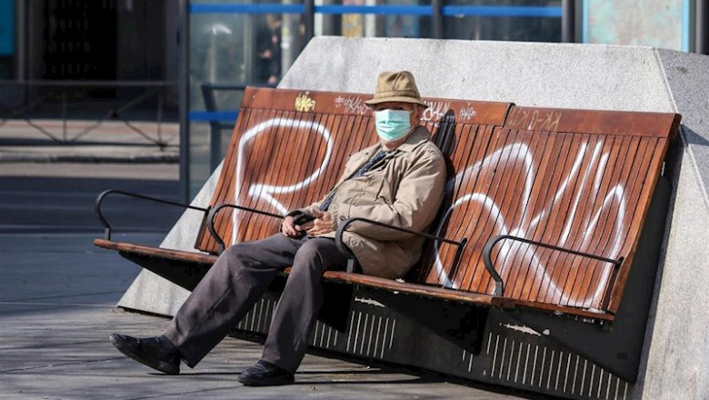 ep un hombre con mascarilla sentado en un banco en madrid durante la crisis del coronavirus en