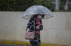 ep una mujer con paraguas y mascarilla durante la alerta amarilla por lluvia