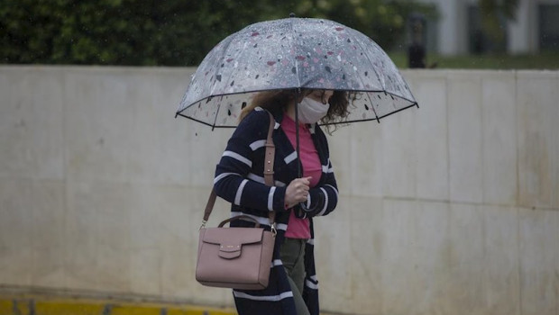 ep una mujer con paraguas y mascarilla durante la alerta amarilla por lluvia