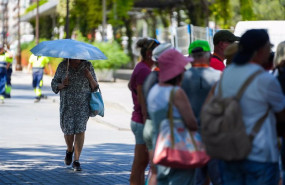 ep una mujer con una sombrilla junto a un grupo de turistas