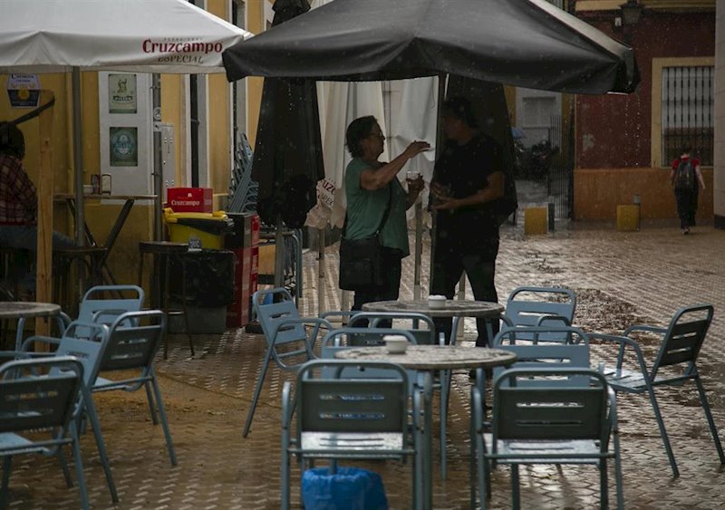 ep clientes de un bar se refugian de la lluvia bajo la sombrilla ep clientes de un bar se refugian de la lluvia bajo la sombrilla