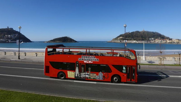 ep un autobus turistico en una carretera junto a la playa de la concha en san sebastian