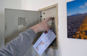 ep archivo   un hombre sube los plomos de la luz con una factura de luz en la mano a 3 de enero de