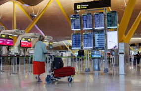 ep una mujer con su equipaje frente a un panel de salidas de la terminal t4 del aeropuerto adolfo