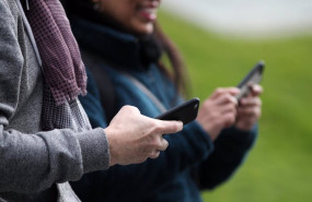 ep archivo   dos personas hacen uso de sus telefonos moviles