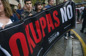 ep archivo   varias personas sujetan un cartel que reza okupas no durante una protesta en barcelona