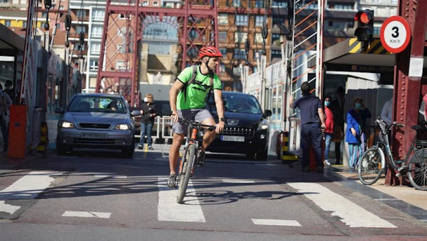 ep un ciclista y dos coches cruzan el puente de vizcaya