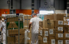 ep trabajadores sanitarios protegidos con mascarilla mueven cajas en el interior del almacen