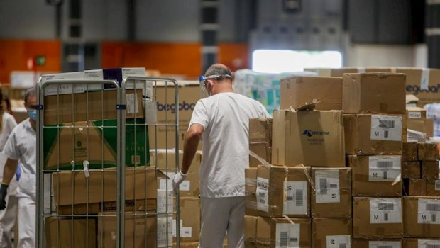 ep trabajadores sanitarios protegidos con mascarilla mueven cajas en el interior del almacen