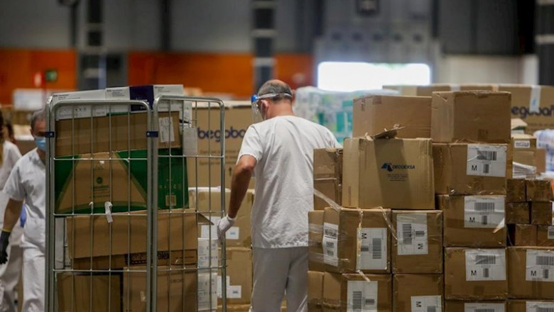 Trabajadores sanitarios protegidos con mascarilla mueven cajas en el interior del almacén habilitado en el hospital provisional de IFEMA para pacientes con Covid-19. | Ricardo Rubio - Europa Press ep trabajadores sanitarios protegidos con mascarilla mueven cajas en el interior del almacen