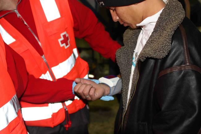 Un voluntario atiende a un inmigrante acabado de llegar | CRUZ ROJA - Archivo ep un voluntario atiendeun inmigrante acabadollegar