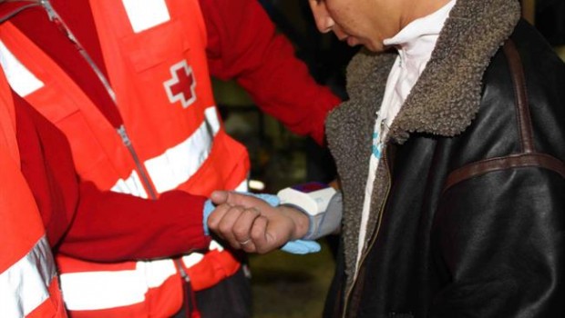 ep un voluntario atiendeun inmigrante acabadollegar