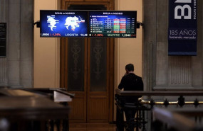 ep una persona camina bajo los televisores indicativos con los valores del ibex en el palacio de la