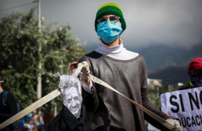 ep a man wearing a face mask and latex gloves holds a caricature image of ecuadorian president lenin