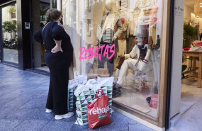 ep archivo   una senora observa un escaparate como muchas bolsas de compras en el suelo
