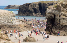 ep turistas pasean por la playa de las catedrales