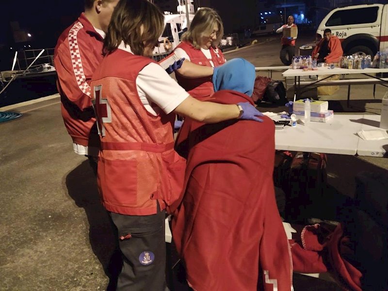 ep miembros de cruz roja atienden a una persona que ha llegado en una de las tres pateras