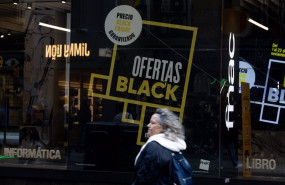 ep una persona pasa por delante de una tienda que anuncia un cartel publicitario del black friday