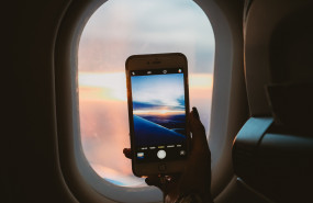 1581325828 person holding smartphone inside airplane 1647116