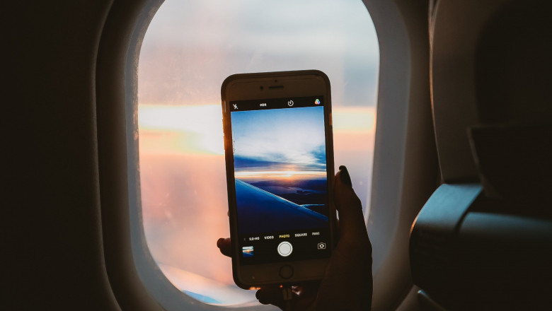 1581325828 person holding smartphone inside airplane 1647116