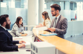 ep archivo   a client are standing at the bank counter while the employee is showing him the
