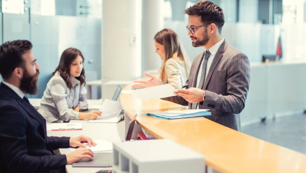 ep archivo   a client are standing at the bank counter while the employee is showing him the