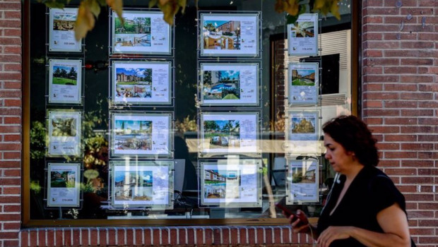 ep archivo   una mujer camina frente a un escaparate de anuncios de viviendas en madrid espana