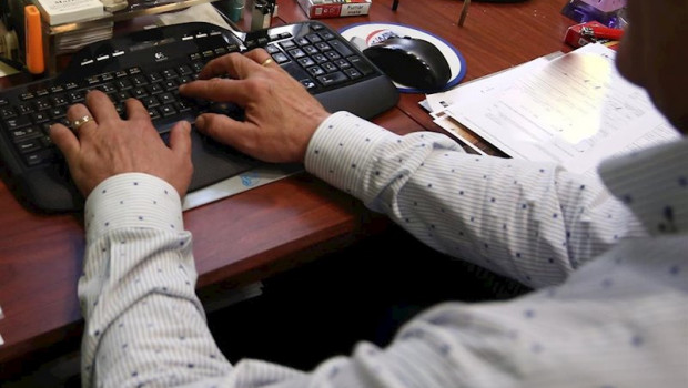 ep las manos de un hombre escriben en el teclado del ordenador en la oficina