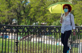 ep mujer pasea con un paraguas amarillo por el puente de triana