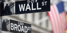 un panneau wall street est suspendu devant un drapeau americain a l exterieur de la bourse de new york 