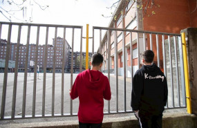 ep dos adolescentes observan el patio cerrado de un colegio durante el confinamiento por el estado