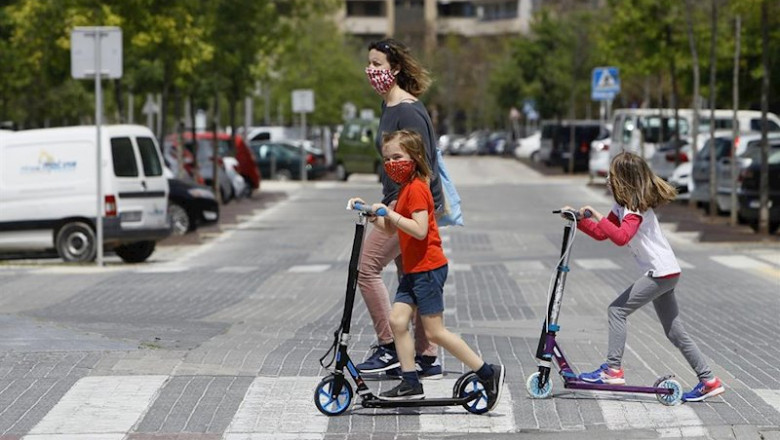 Dos niñas con mascarillas cruzan un paso de cebra montadas en patinete tras salir a la calle el primer día en el que los menores de 14 años lo pueden hacer durante el estado de alarma decretado por el Gobierno por la pandemia del coronavirus, en Palma de | Isaac Buj - Europa Press ep dos ninas con mascarillas cruzan un paso de cebra montadas en patinete tras salir a la calle el